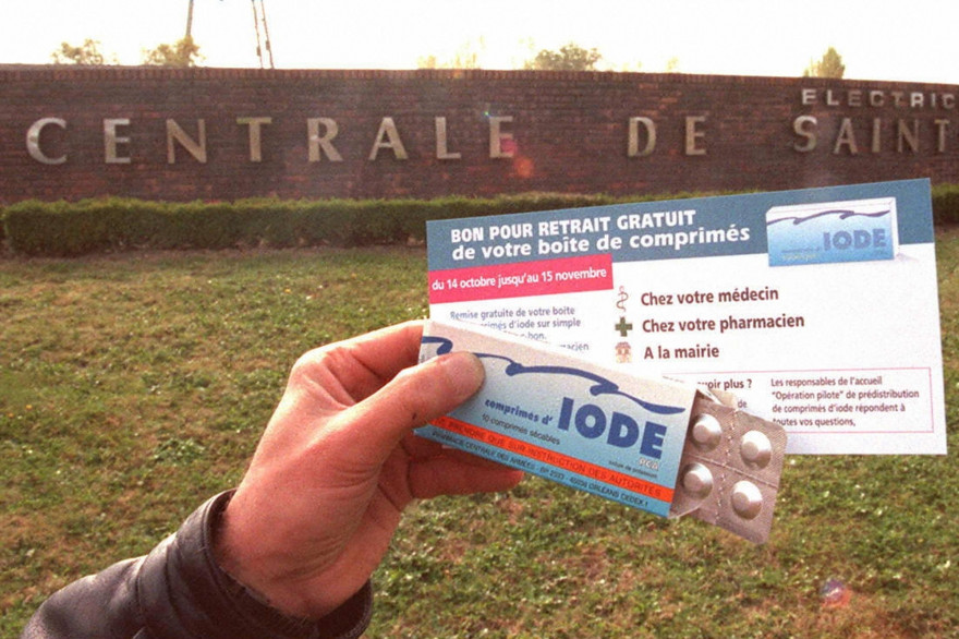 Photo prise le 14 octobre 1996 d'une personne présentant une fiche d'informations et une boîte de comprimés d'iode devant la centrale nucléaire de Saint-Alban.