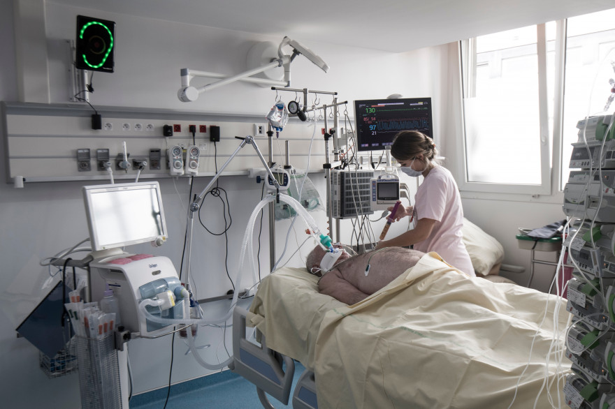 Une soignante auprès d'un patient dans un hôpital de l'AP-HP