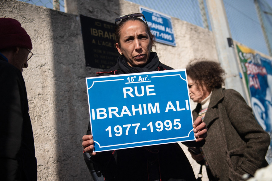 Une femme tenant une pancarte de rue au nom d'Ibrahim Ali lors d'une commémoration à Marseille, le 21 février 2020, alors que les proches de la victime demandait une inauguration officielle de l'avenue.