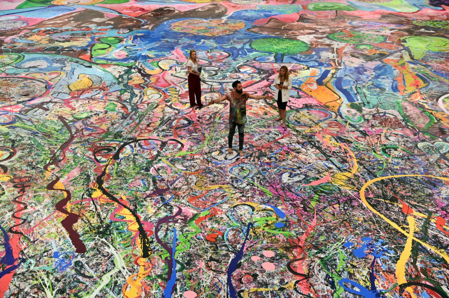 L'artiste Sacha Jafri au milieu de son tableau "Journey of Humanity", le plus grand du monde