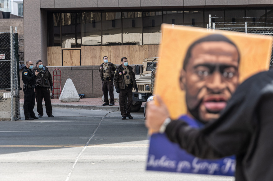 Un manifestant brandit un portrait de George Floyd devant le tribunal de Minneapolis