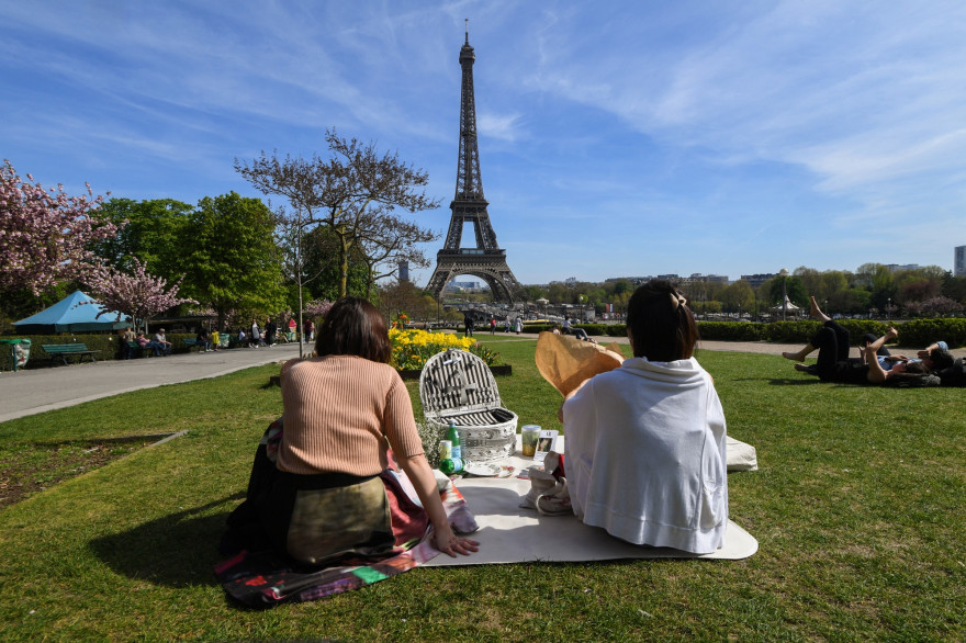 Deux personnes faisant un pique-nique face à la Tour Eiffel à Paris.