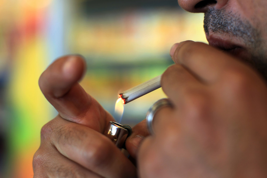 Un homme allume une cigarette (illustration).