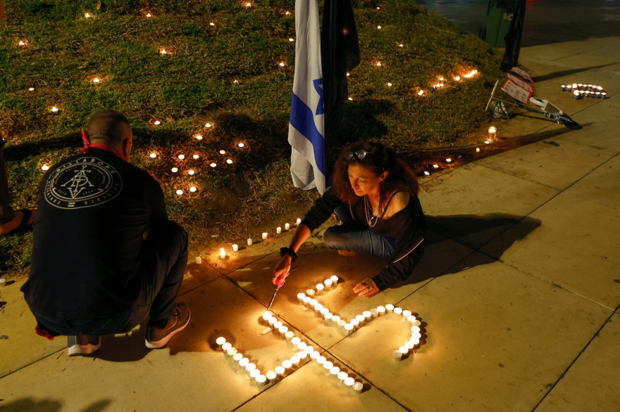 Des bougies scintillent près d’un drapeau israélien lors d’une veillée sur la place Habima, dans la ville côtière de Tel Aviv, le 1er mai 2021, au lendemain d’une bousculade meurtrière dans une ville de pèlerinage juive du nord du pays.