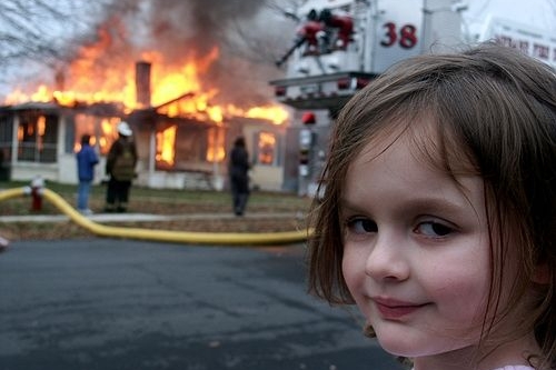 Disaster Girl est un mème Photoshop dans lequel une photo d'une jeune fille souriante est superposée à des images d'accidents, ce qui implique qu'elle a causé le chaos représenté en arrière-plan.