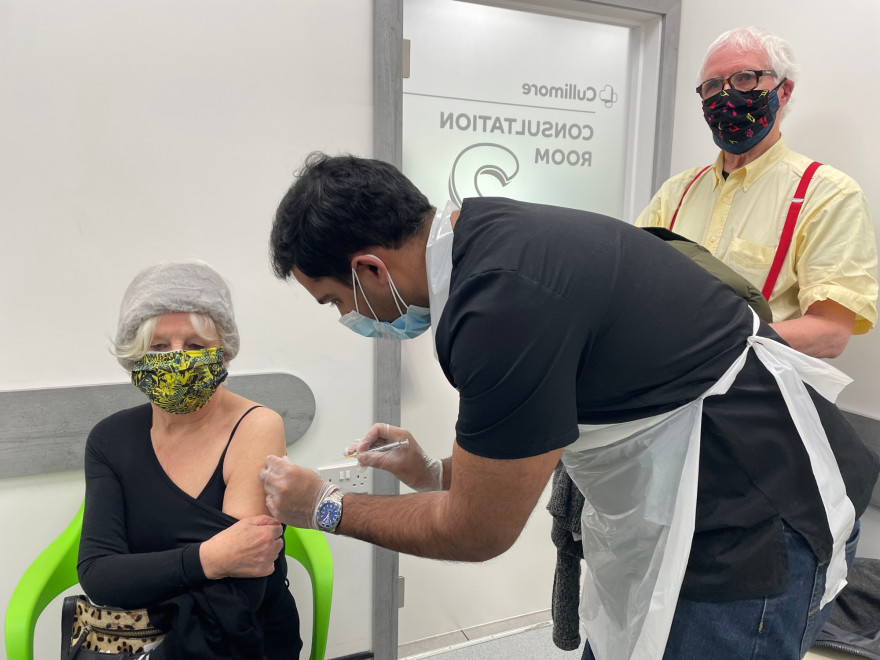 Marjorie et Michael, 81 et 82 ans, reçoivent les vaccins des mains du Dr Asif, dentiste formé pour participer à la campagne de vaccination en pharmacie